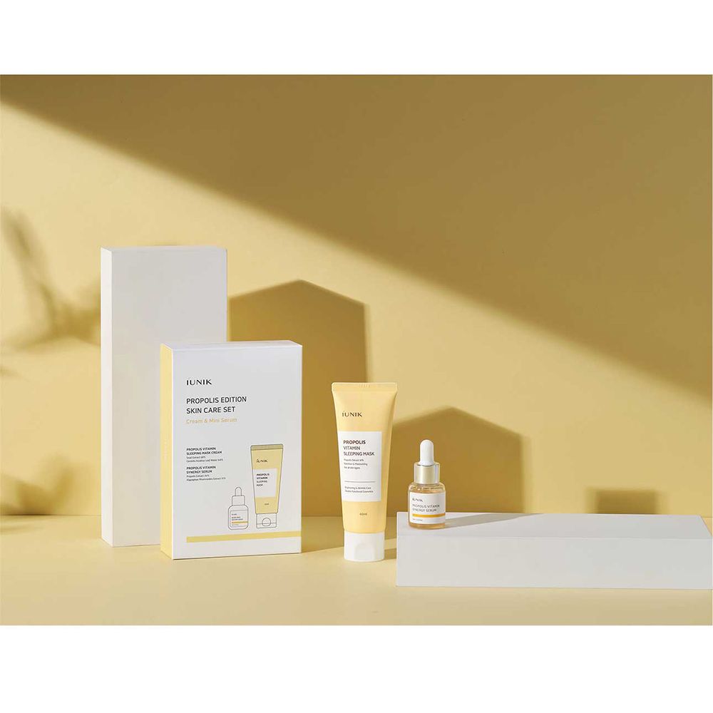 iUNIK Propolis Edition Skin Care Set, tubo e flacone siero. Su blocchi bianchi, sfondo giallo.