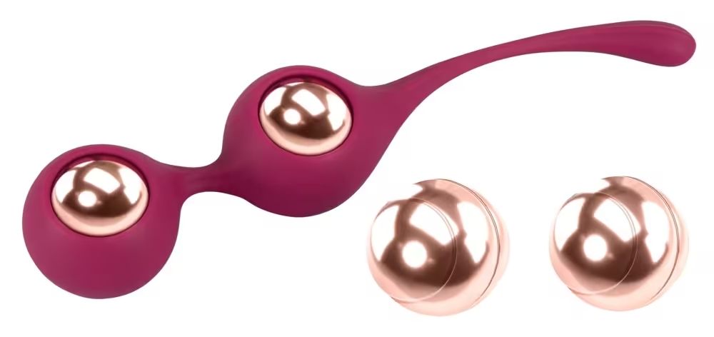 Due sfere per esercizi pelvici con due sfere separate. Le sfere sono rosa e dorate. Le sfere sono collegate e hanno una forma allungata.