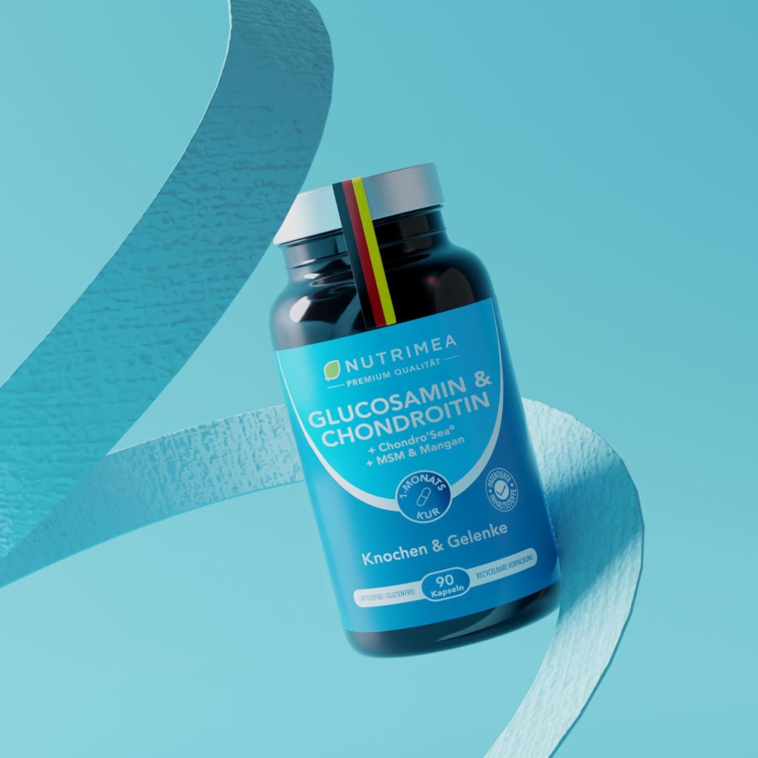 Flacone scuro con etichetta blu. Scritta: Nutrimea, Glucosamina & Condroitina. Con bandiera tedesca. Nastro decorativo.