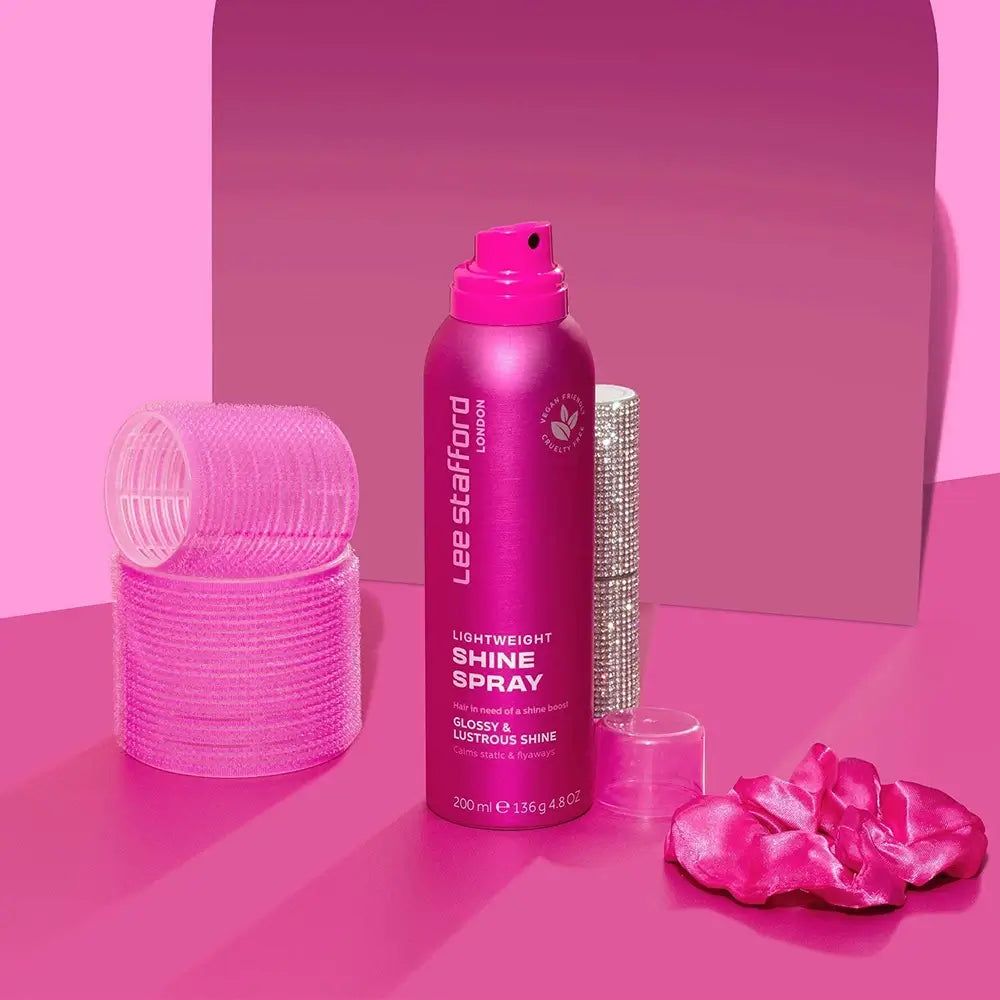Flacone di spray lucidante leggero Lee Stafford con bigodini rosa e rossetto scintillante.