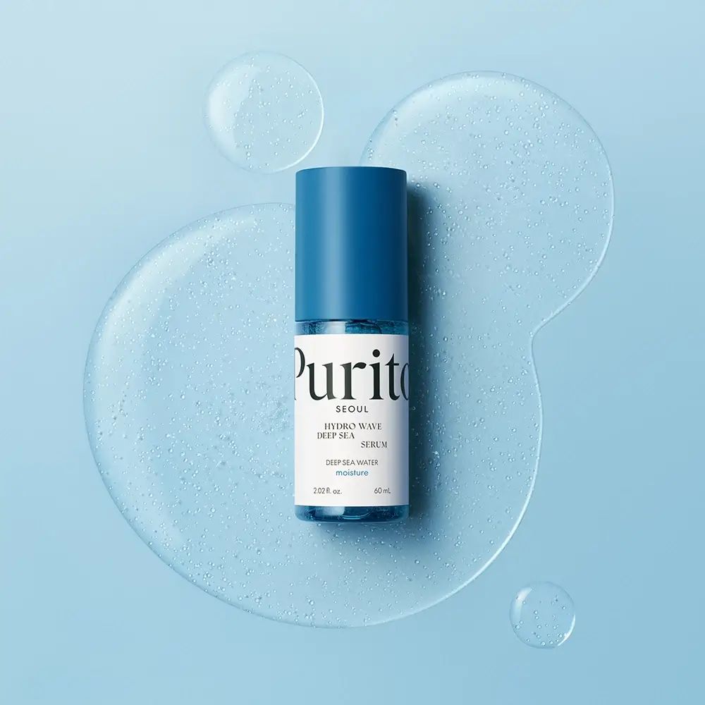 Flacone blu e bianco con tappo blu. Scritta: Purito Seoul, Hydro Wave Deep Sea Serum. Su sfondo blu.