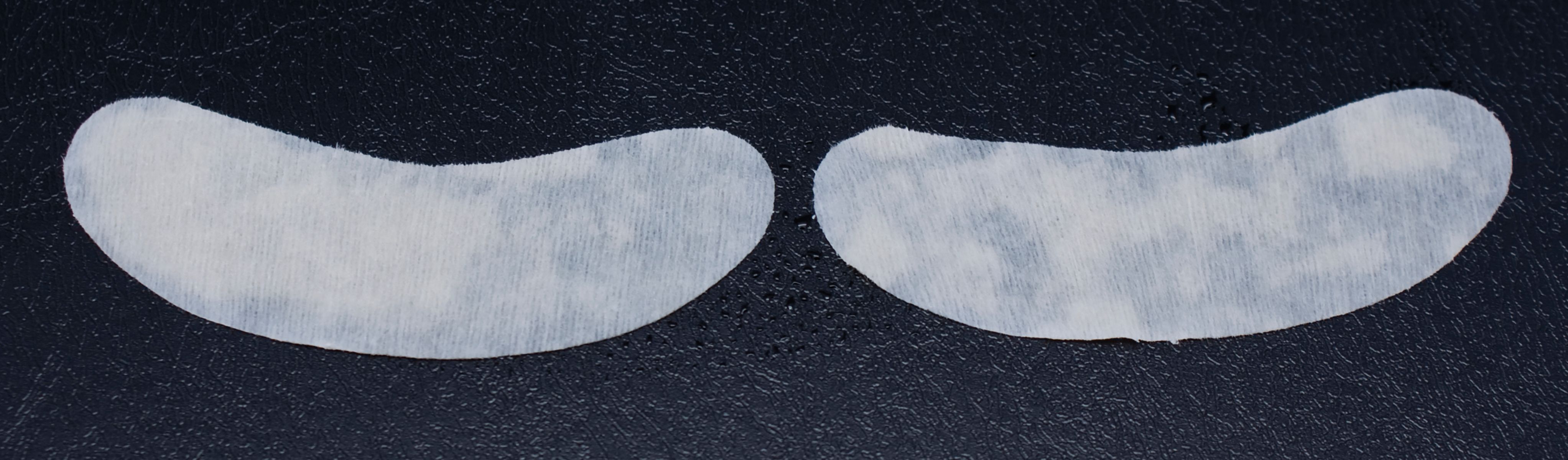 Due patch bianchi per occhi su sfondo scuro. Forma a mezzaluna.
