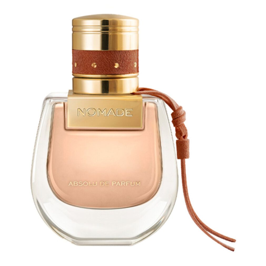 Flacone di profumo con tappo dorato, cinturino in pelle marrone. Scritta 'Nomade Absolu de Parfum'. Flacone trasparente.