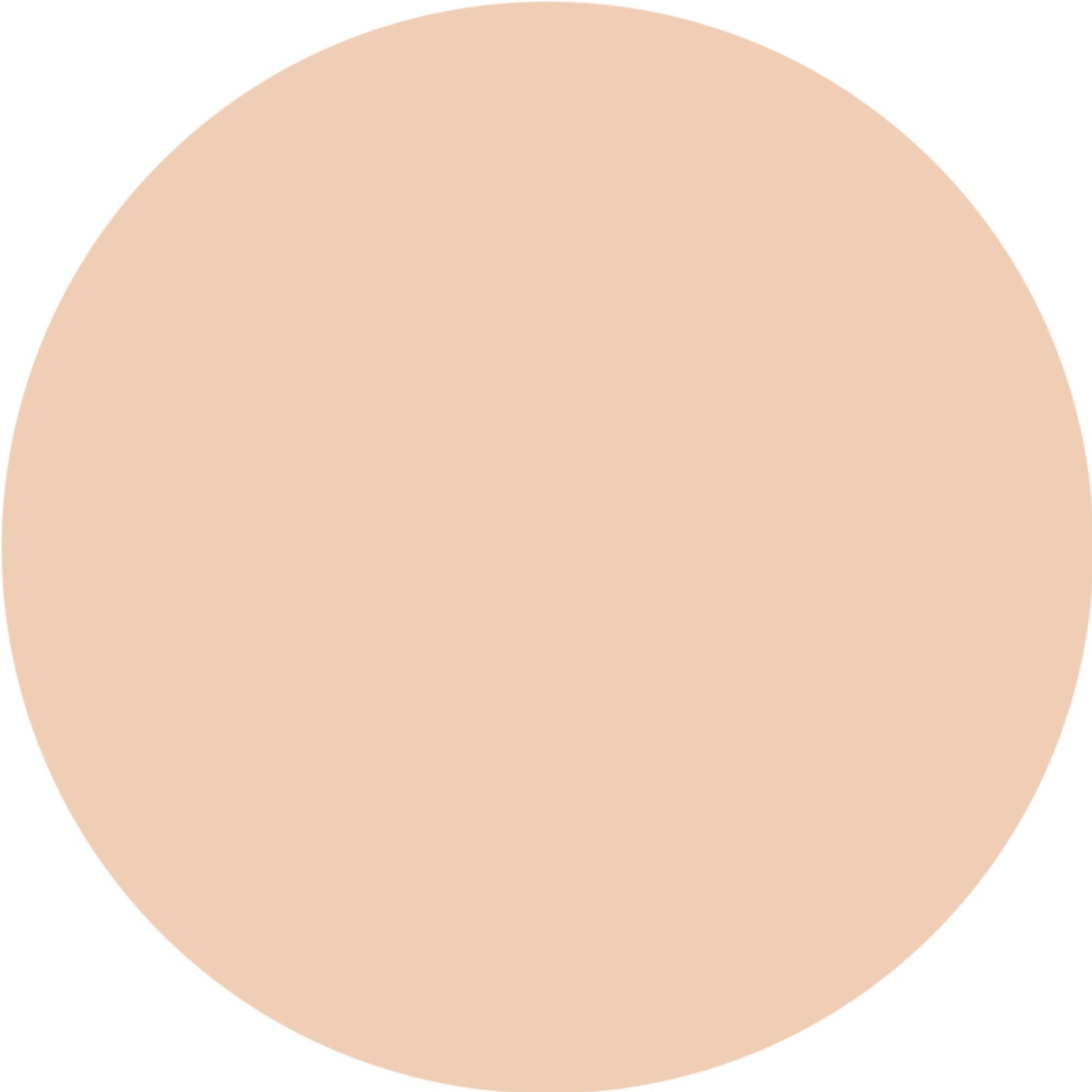 Macchia circolare di correttore beige su sfondo bianco.