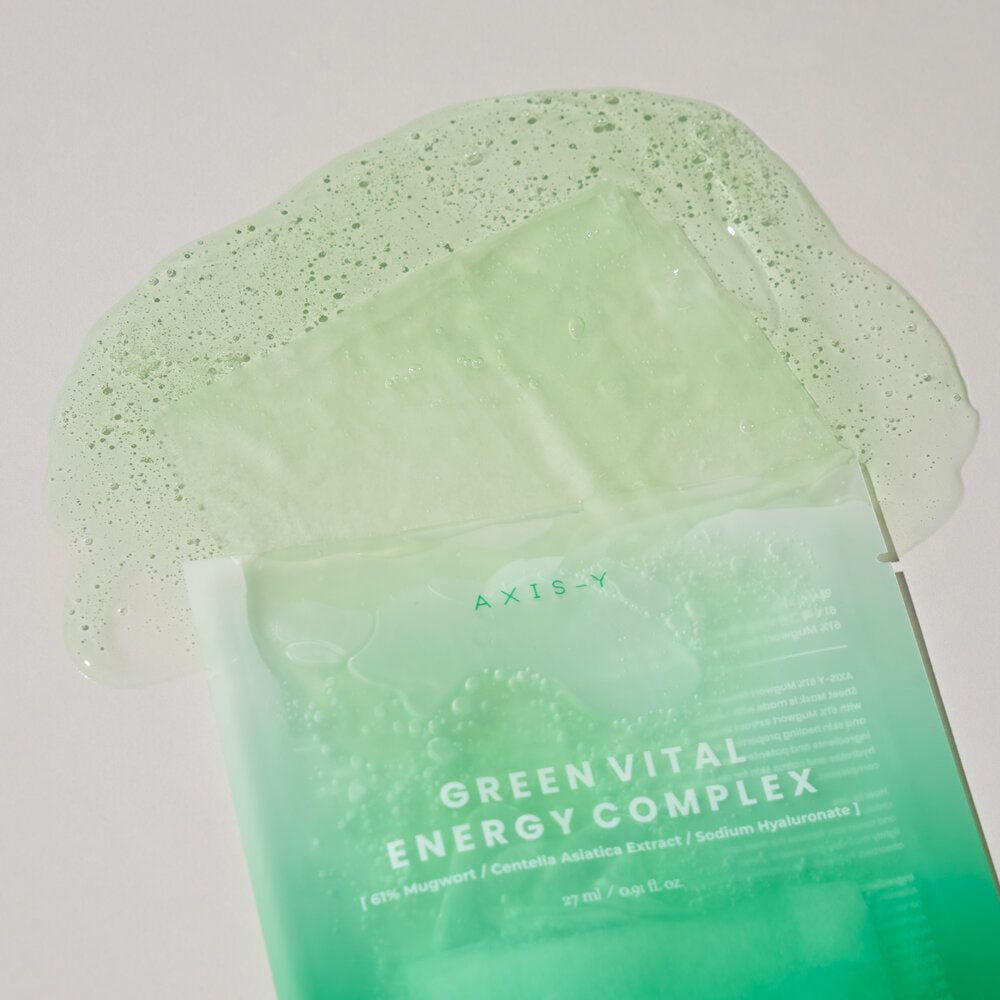 Confezione di maschera verde aperta con maschera e liquido. AXIS-Y in alto. Testo: GREEN VITAL ENERGY COMPLEX.