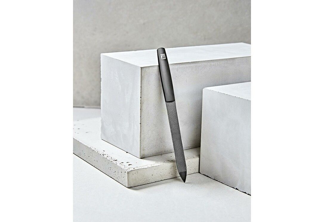 Un accessorio per lime per unghie scuro, a forma di penna, con texture fine e punta affilata.
