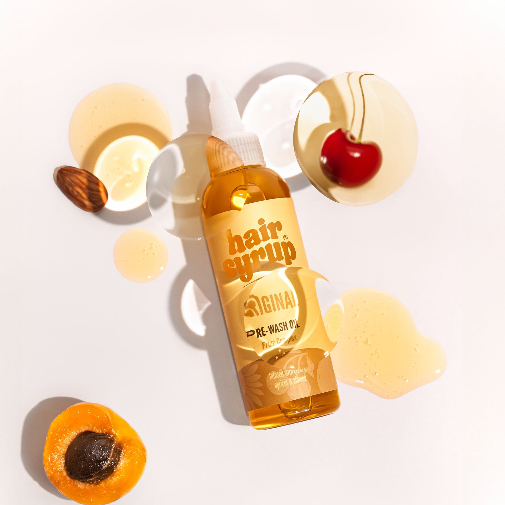 Bottiglia di Hair Syrup The Original con ciliegia, albicocca e mandorla. Sfondo chiaro. Etichetta del prodotto visibile.
