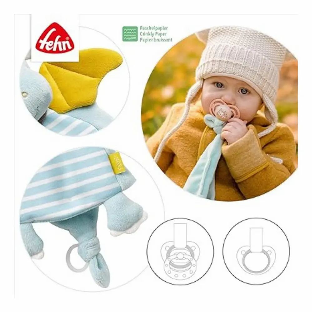Bambino con ciuccio e peluche a forma di drago blu e giallo. Marchio: fehn. Disegni di ciucci.