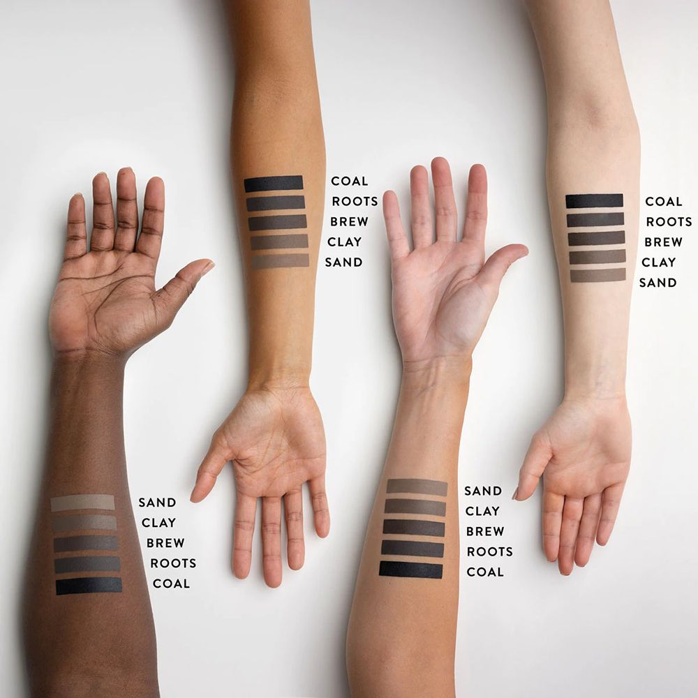 Braccia con campioni di pomata per sopracciglia. Colori: Coal, Roots, Brew, Clay, Sand. Nomi sulle braccia.