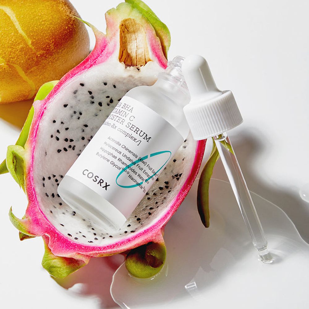 Flacone di siero con pipetta, accanto a metà frutto del drago. Scritta: COSRX AHA BHA Vitamin C Booster Serum.