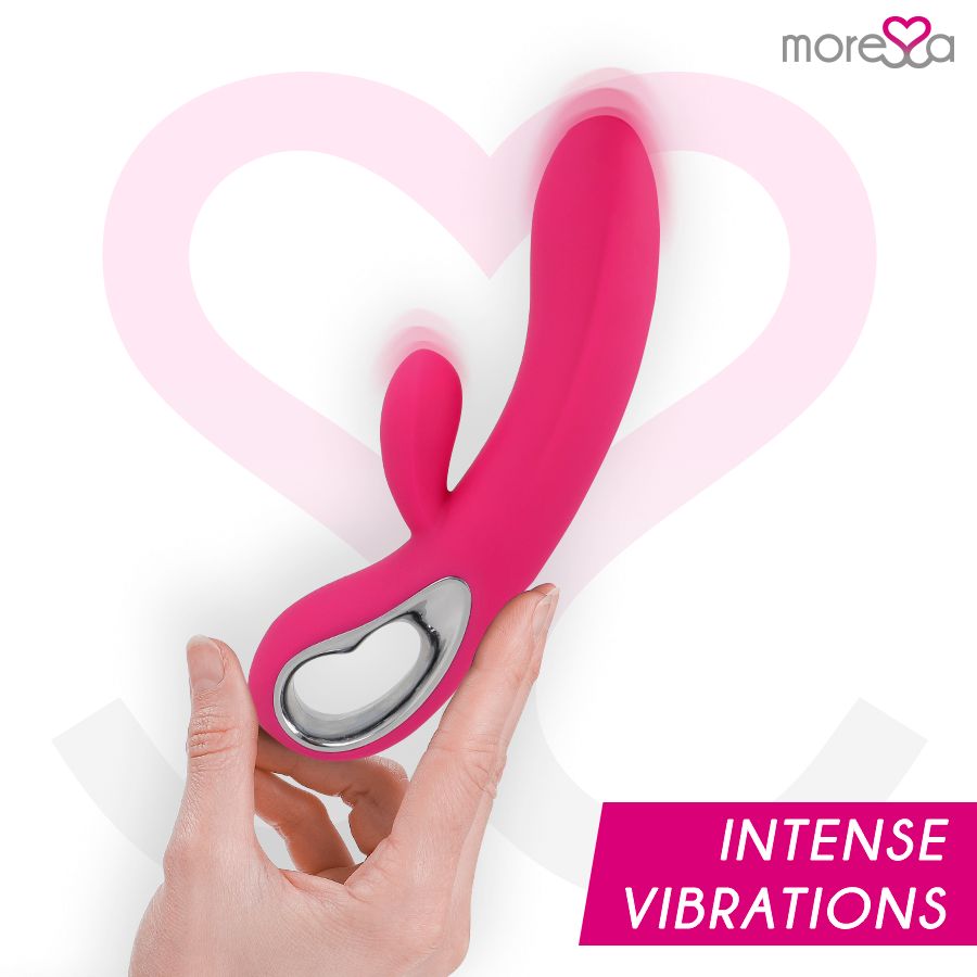 Mano che tiene un vibratore in silicone rosa con anello argentato. Testo: Intense Vibrations.