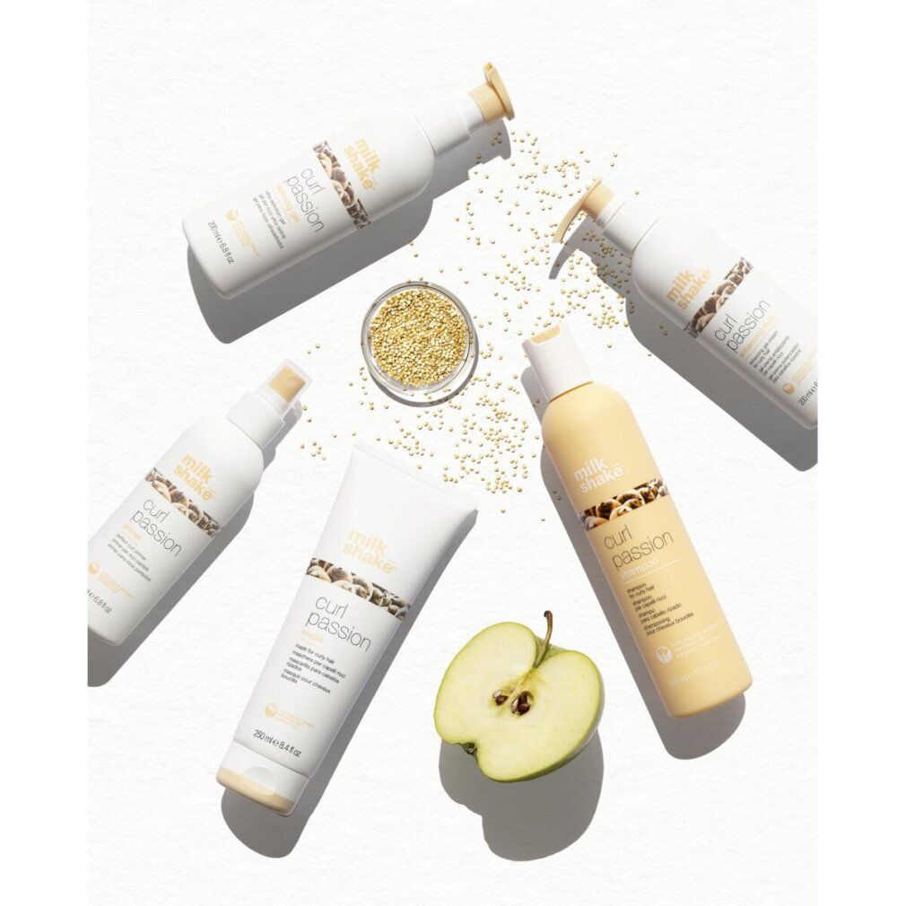 Vari prodotti "milk shake curl passion", tra cui tubi e flaconi. Mezza mela e semi.