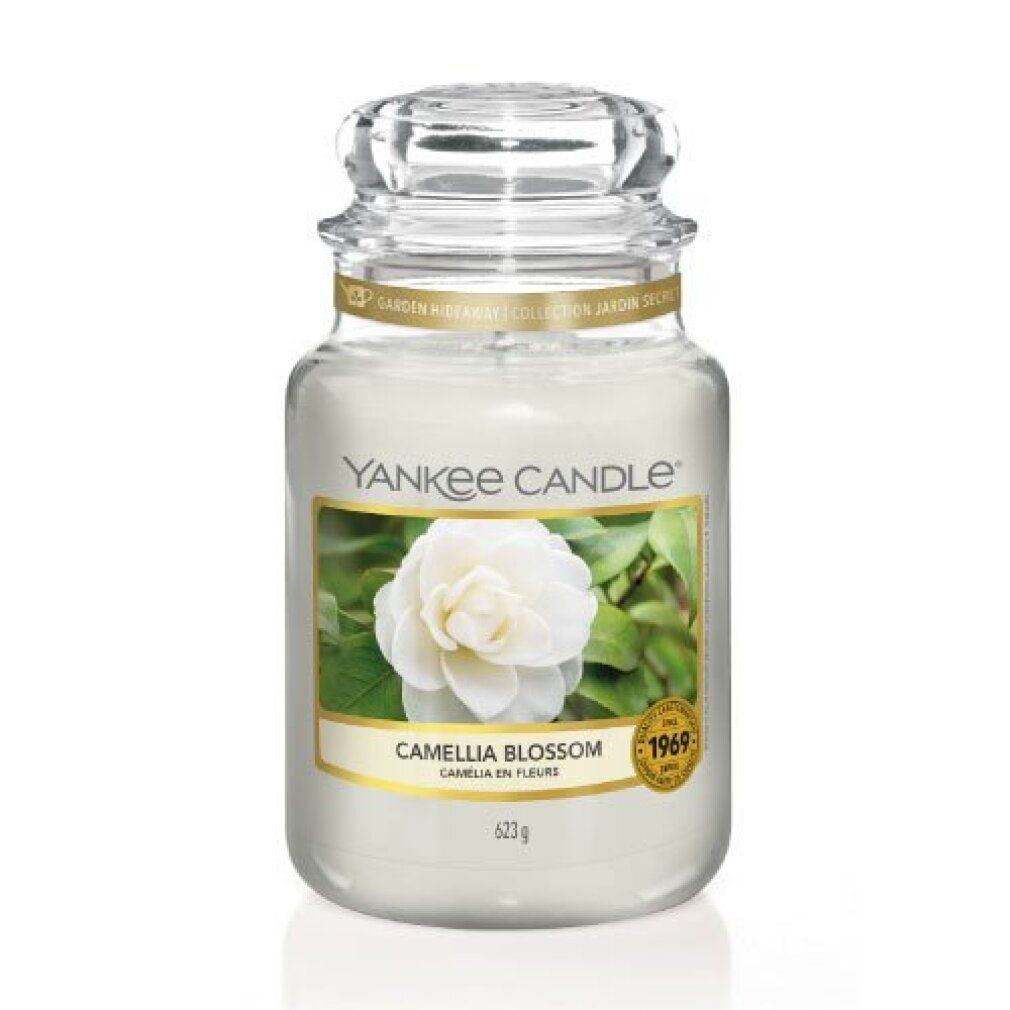 Vaso di candela con coperchio. Etichetta con fiore e testo. Bordo dorato. Marchio: Yankee Candle. Scritta: Camellia Blossom, 623g.
