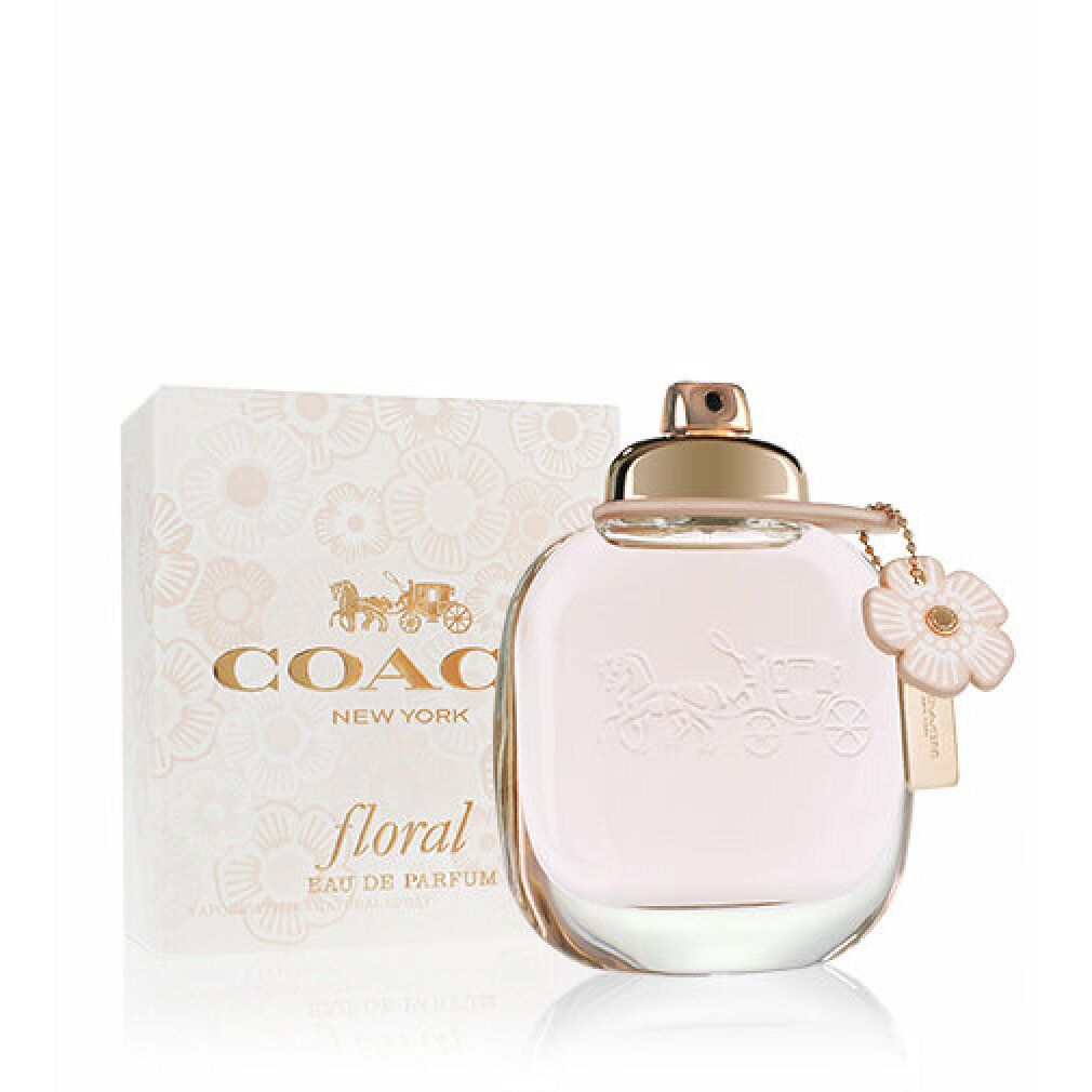 Flacone di profumo e scatola. Flacone rotondo rosa con design a carrozza in rilievo. Scatola con motivi floreali e testo.