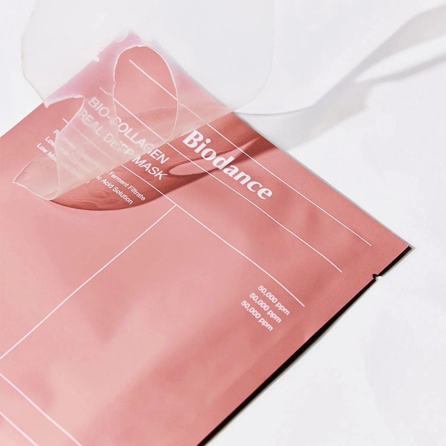 Confezione rosa con nome del prodotto. Testo: Bio Collagen Real Deep Mask. Parzialmente aperta, maschera visibile.