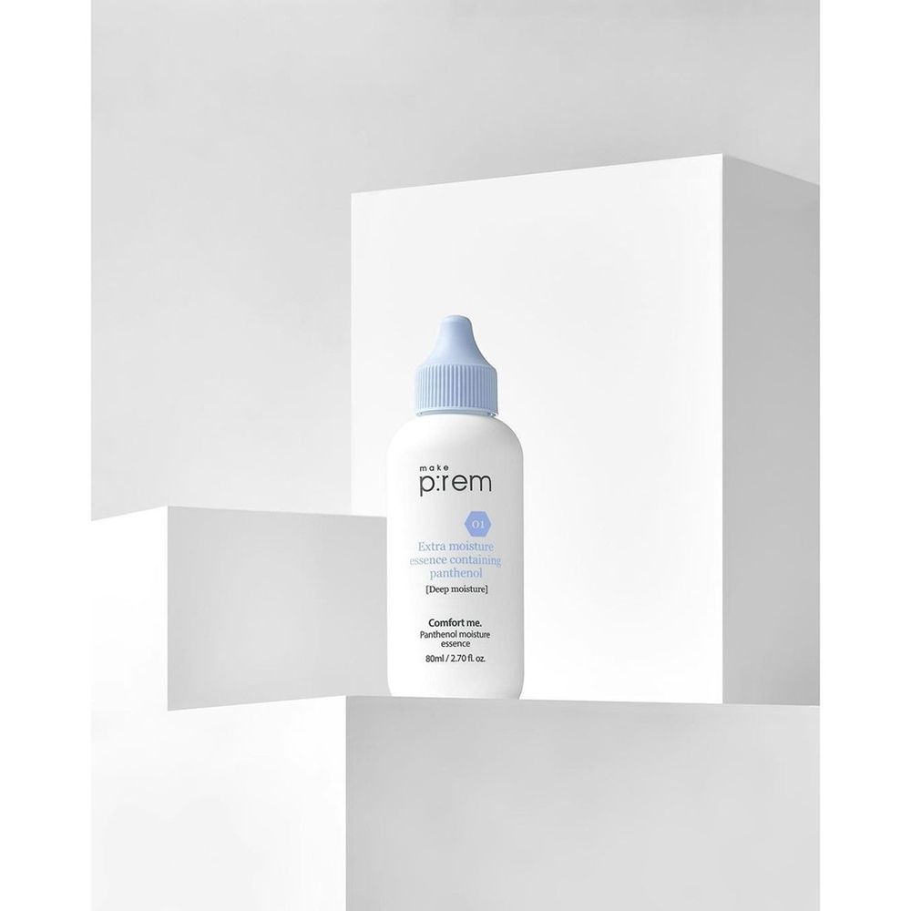 Flacone bianco con tappo blu su piedistallo bianco. Scritta: make p:rem, Extra Moisture Essence, Comfort me.