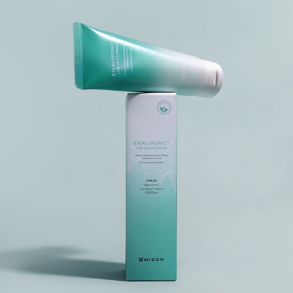 Mano che tiene un tubetto con schiuma. Scritta: Cicaluronic Low pH Cleanser. Marchio Mizon. Verde e bianco. Per pelli sensibili.