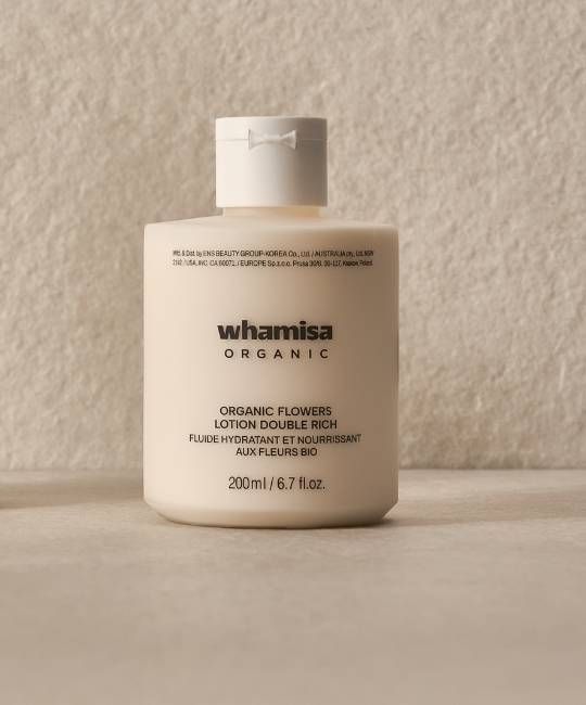 Flacone di lozione beige con tappo bianco. Scritta: WHAMISA ORGANIC, ORGANIC FLOWERS LOTION DOUBLE RICH.