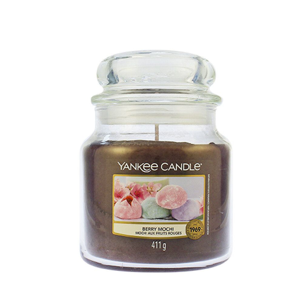 Candela profumata in vaso con coperchio. Etichetta con immagine di mochi e testo. 411g. Marchio Yankee Candle.