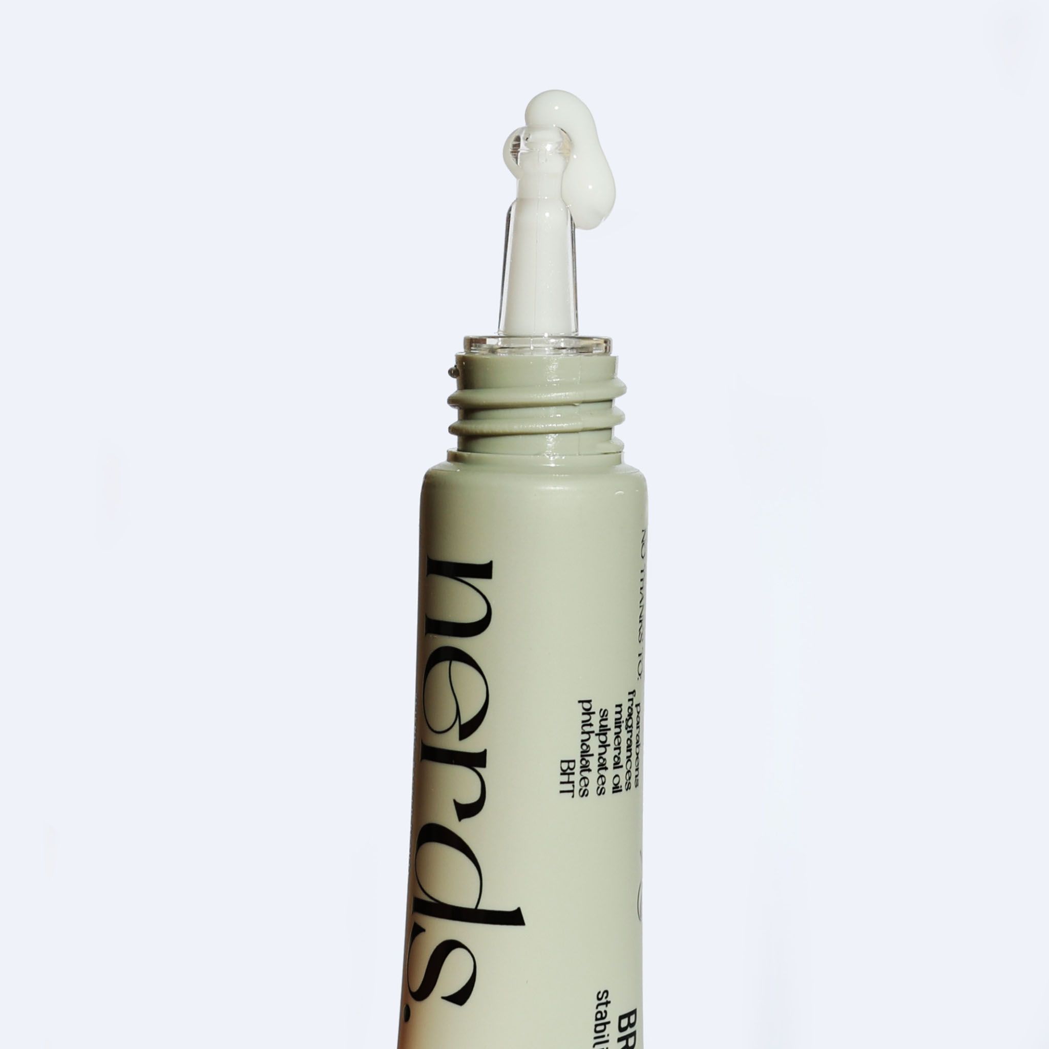 Un tubetto con applicatore da cui fuoriesce crema bianca.