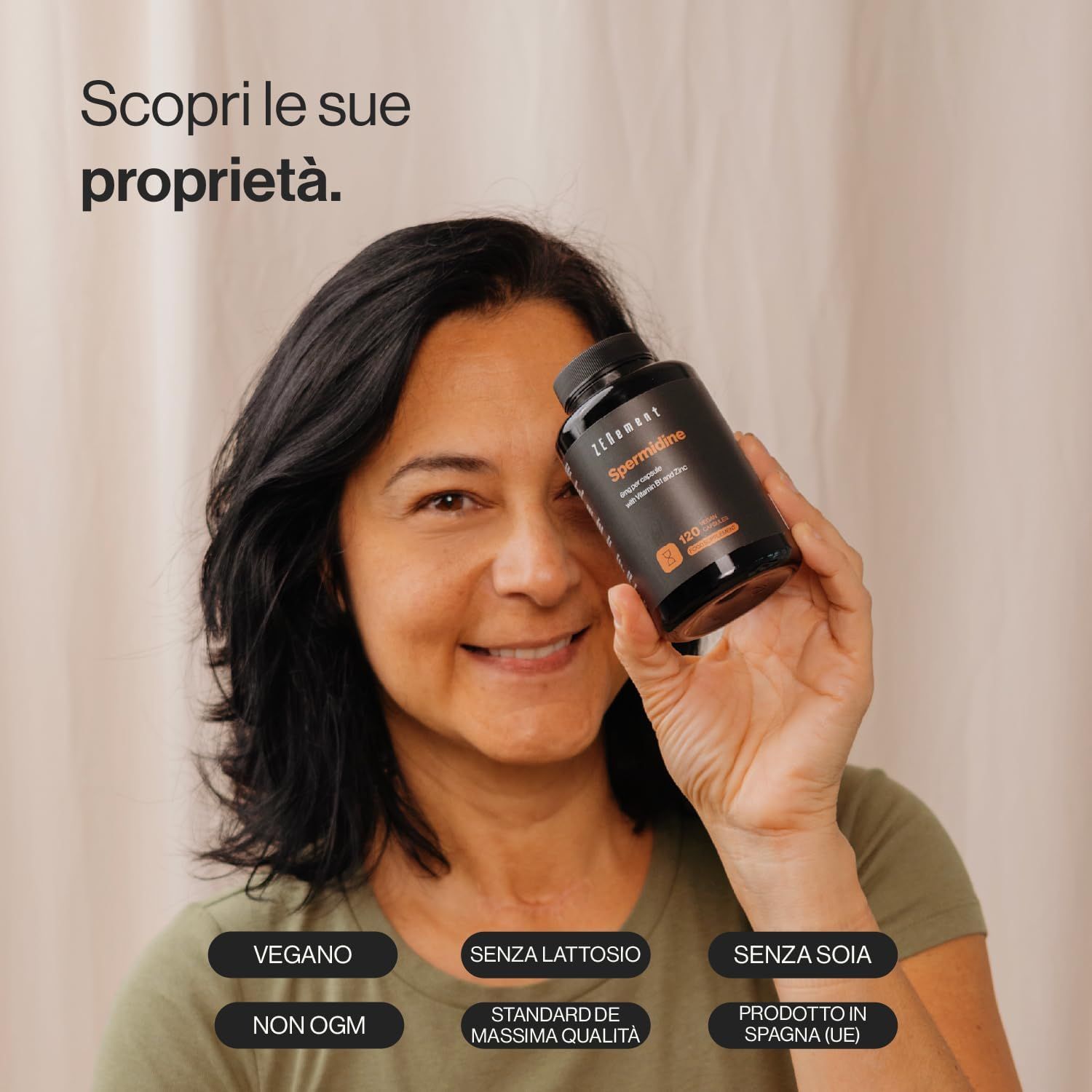 Donna tiene flacone di capsule di spermidina. Testo: Vegano, senza lattosio, senza soia, senza OGM, standard di qualità, prodotto in Spagna.