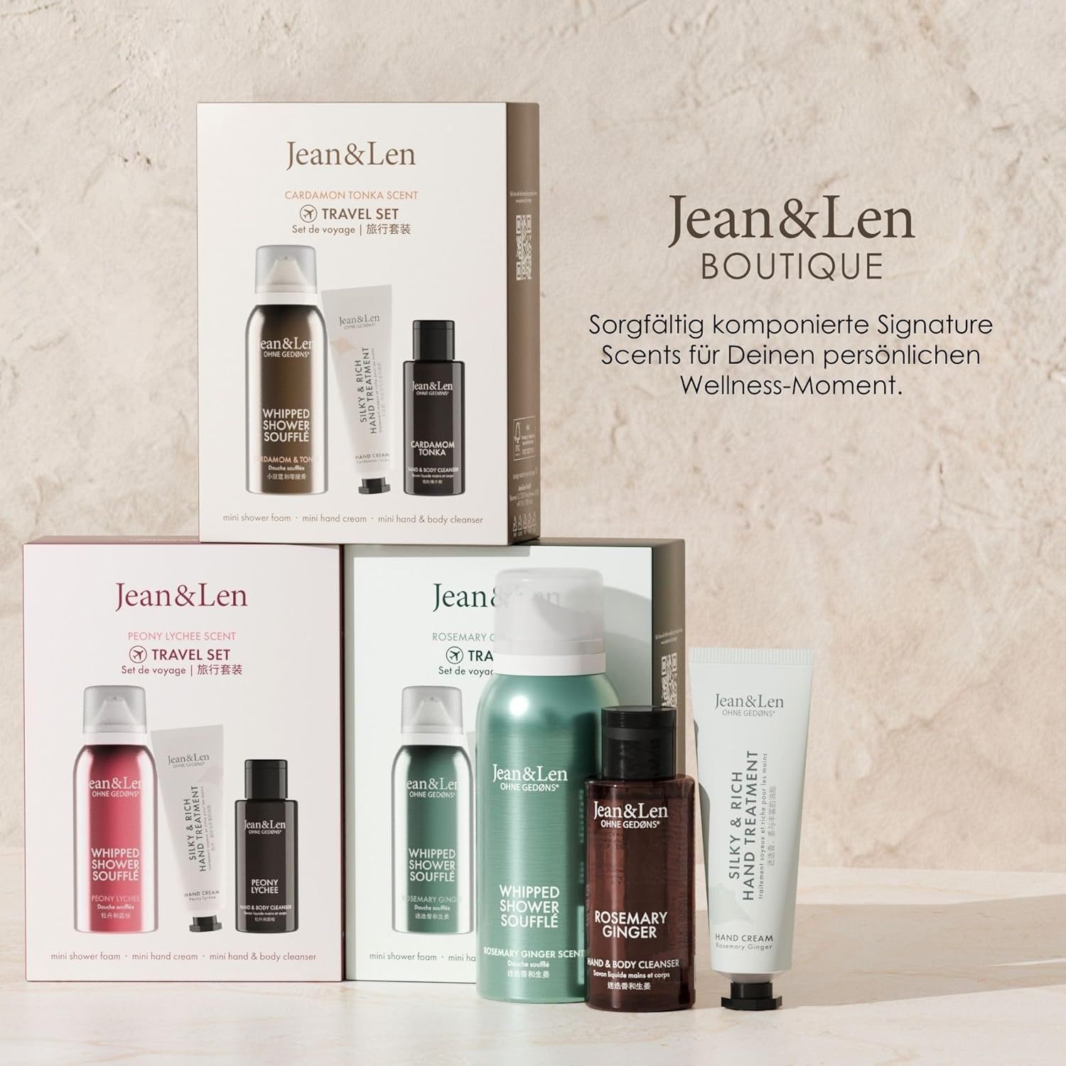 Diversi Travel Set. Testo: "Jean & Len Boutique". Vari prodotti, tra cui schiuma doccia, crema mani e detergente mani e corpo.