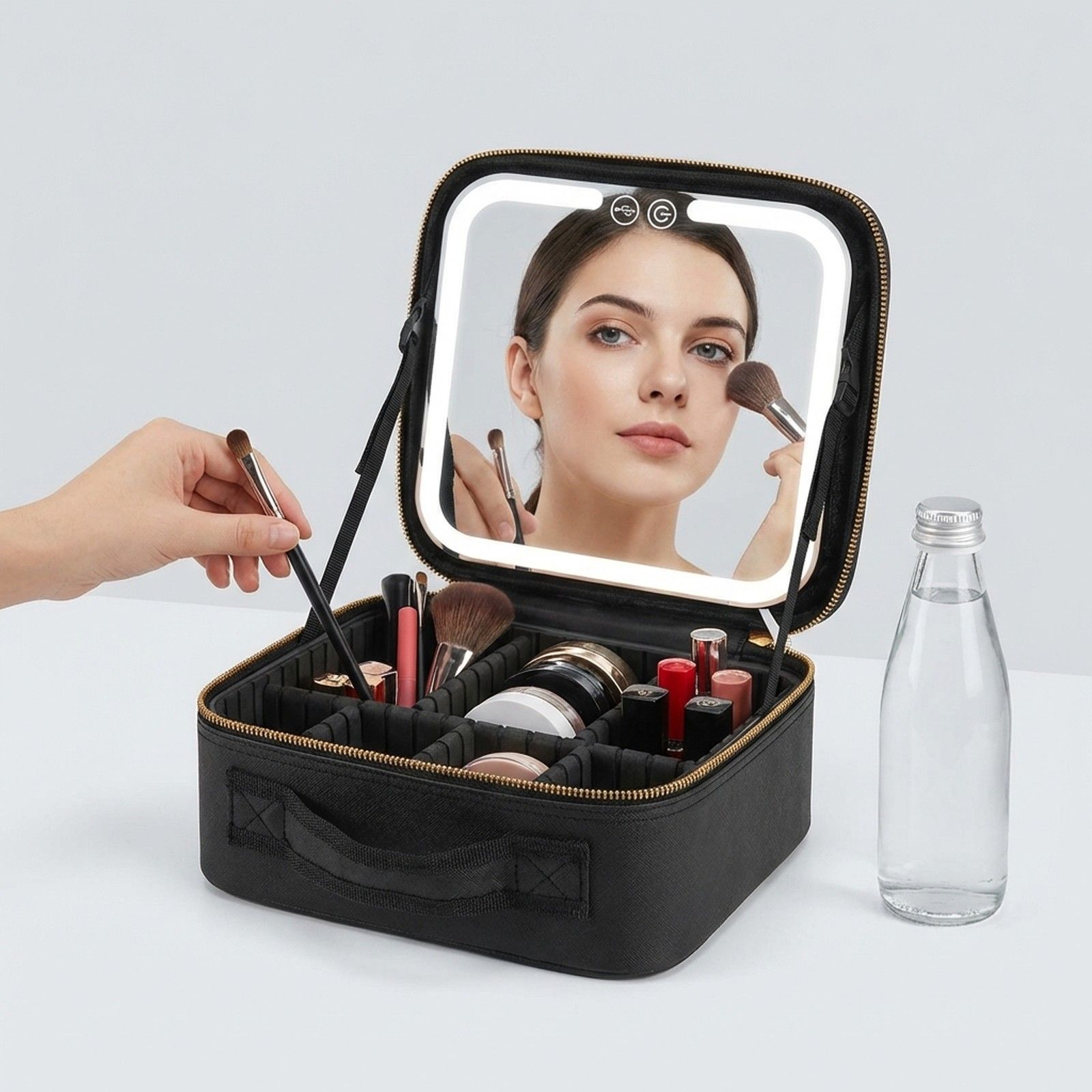 Beauty case nero con specchio illuminato e scomparti.