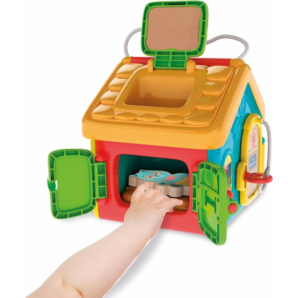 Bambino che afferra un personaggio animale in una casa gioco aperta. Casa gioco multicolore con diverse aperture.
