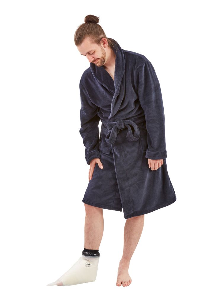 Uomo in accappatoio con protezione per piede ingessato. Involucro bianco trasparente, bordo nero. Marchio Limbo.