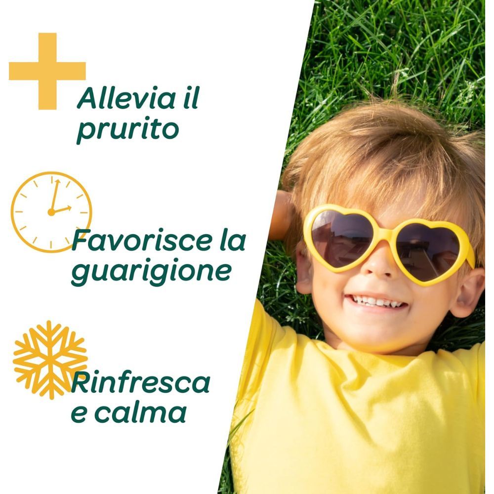 Bambino con occhiali da sole sdraiato sull'erba. Testo: Allevia il prurito, Favorisce la guarigione, Rinfresca e calma.
