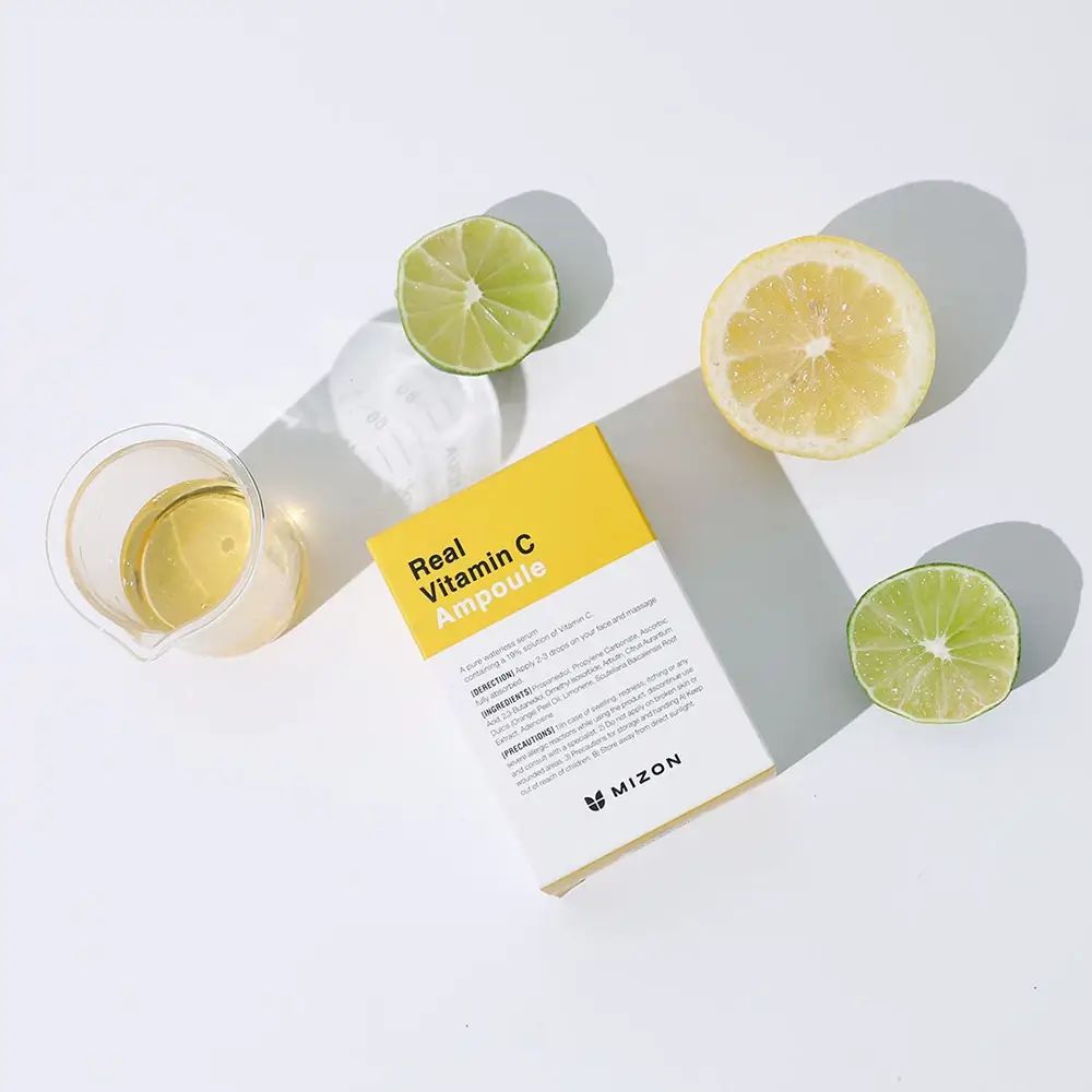 Confezione MIZON Real Vitamin C Ampoule, etichetta gialla, limoni, lime, becher con liquido. Sfondo bianco.