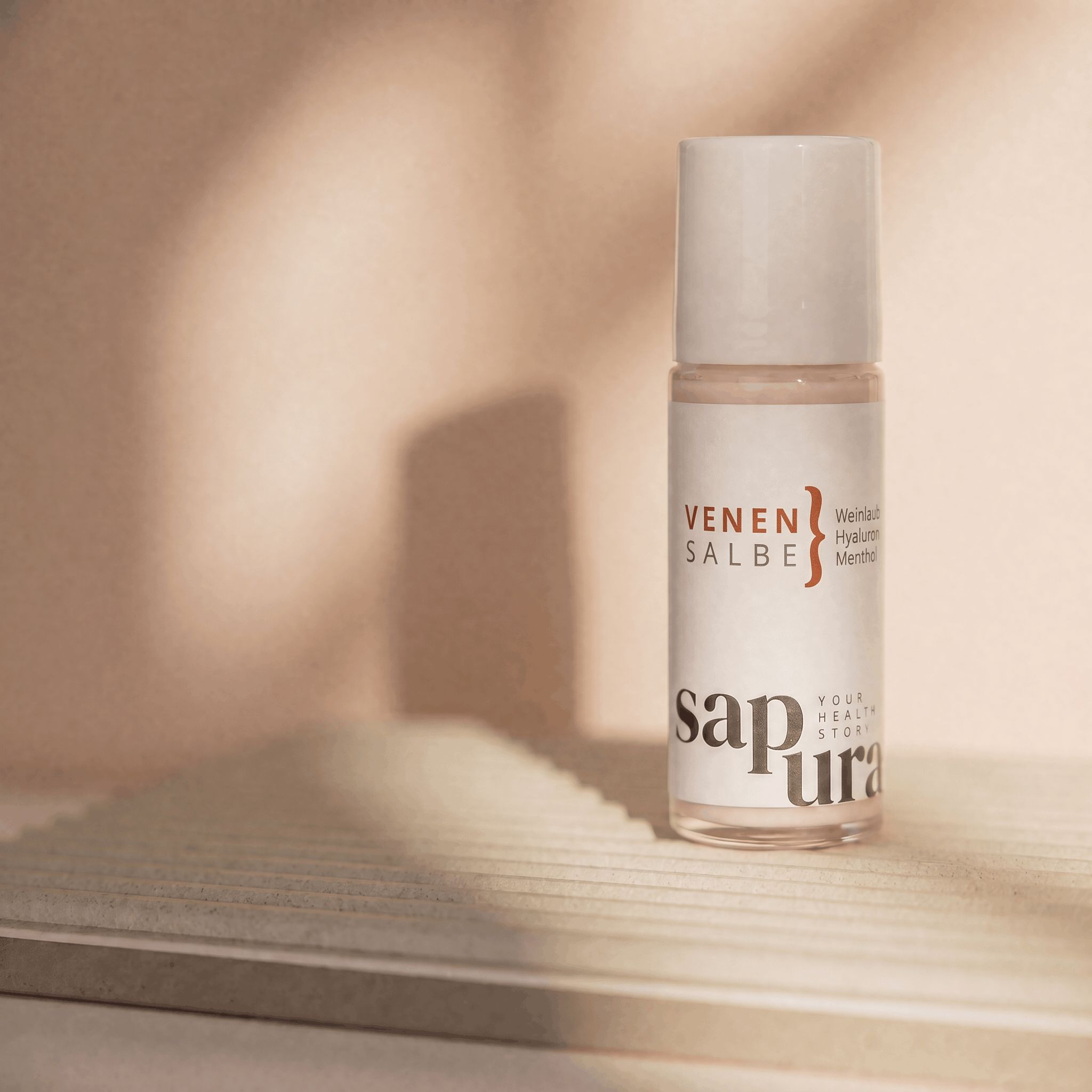 Roll-on Venensalbe su una superficie chiara con ombre.