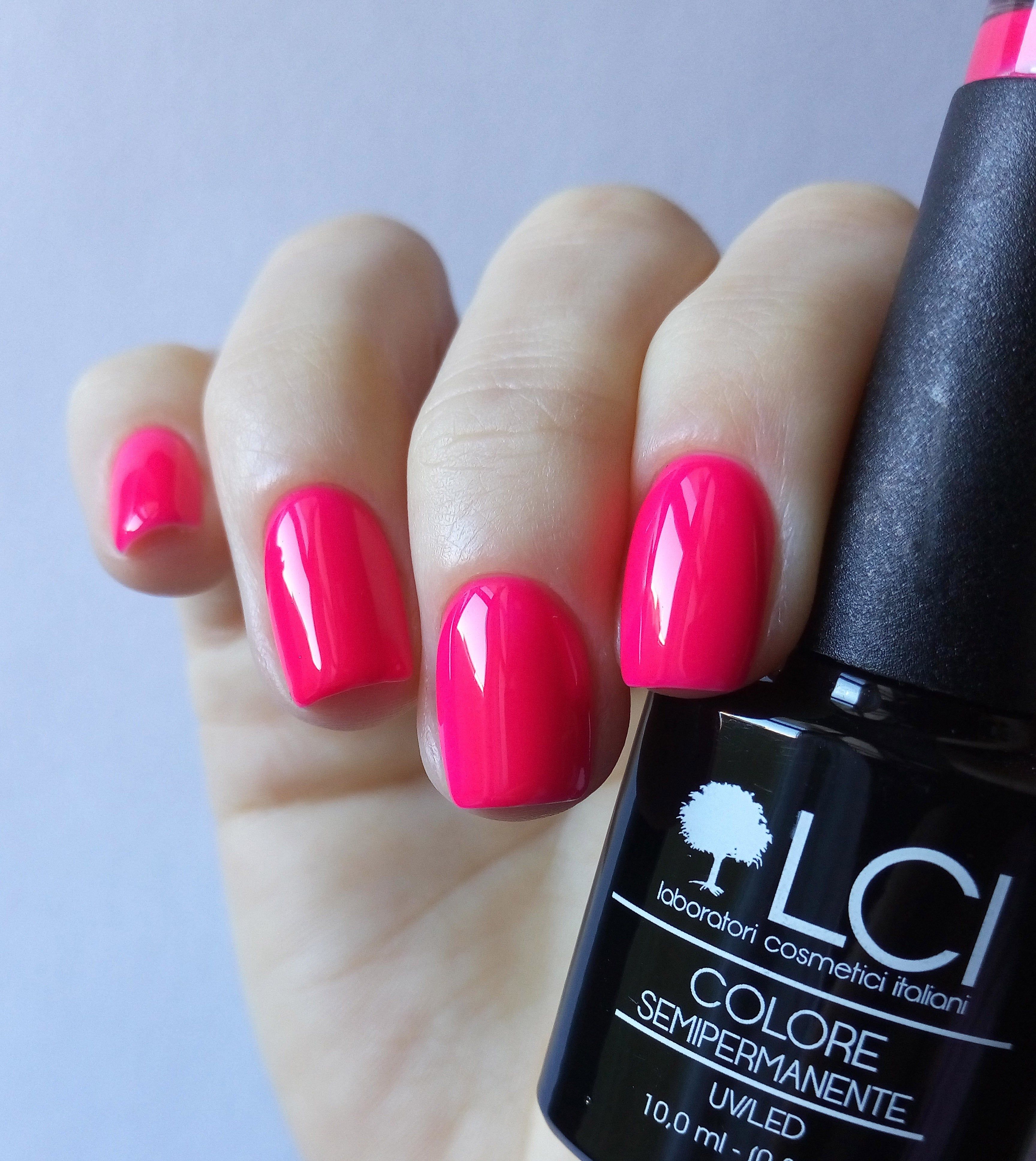 Mano con unghie smaltate rosa fucsia. Flacone con scritta: LCI, Colore Semipermanente, UVLED.