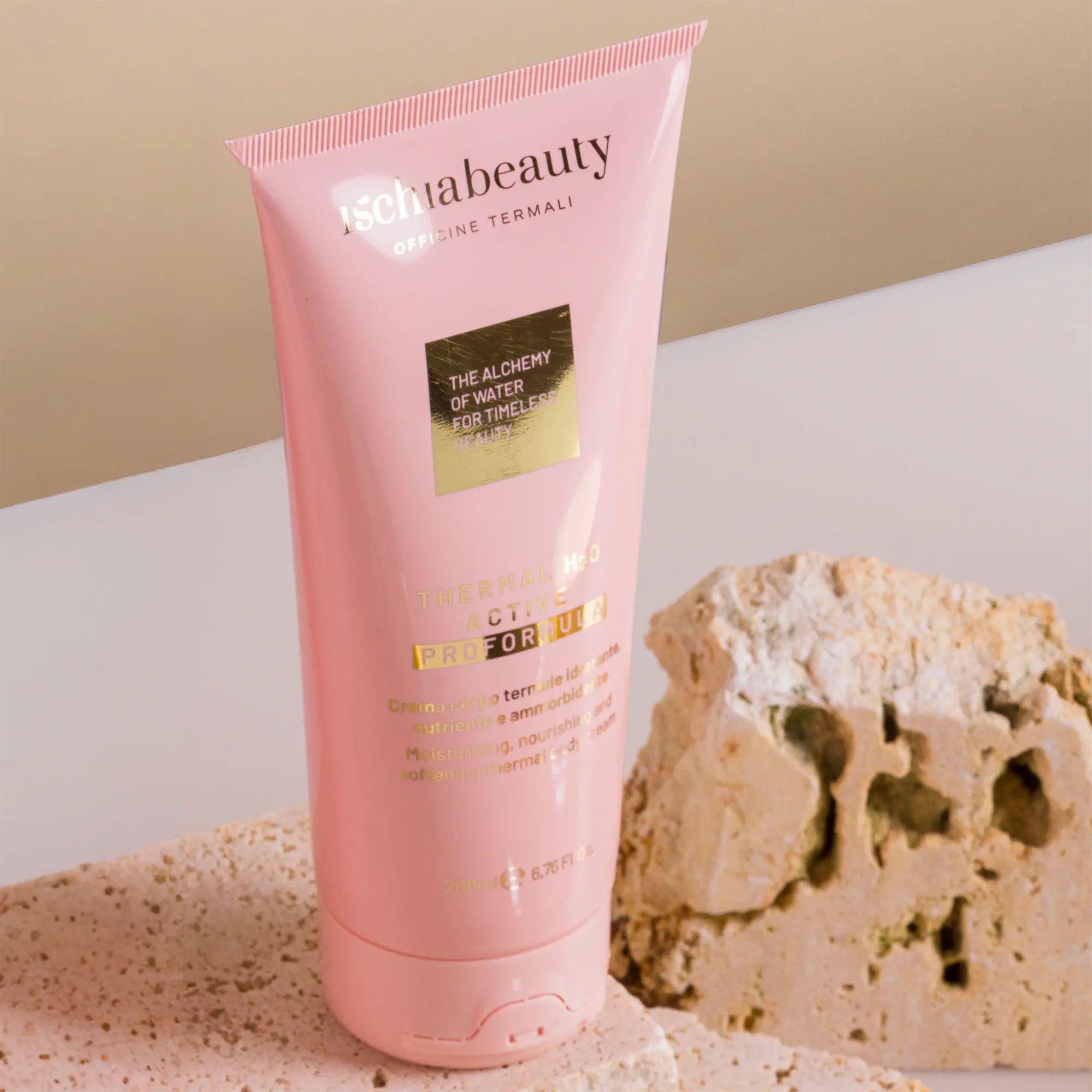 Tubo rosa con testo del prodotto. Scritta: ischiabeauty, Thermal H2O Active Pro Formula. Accanto a pietra.