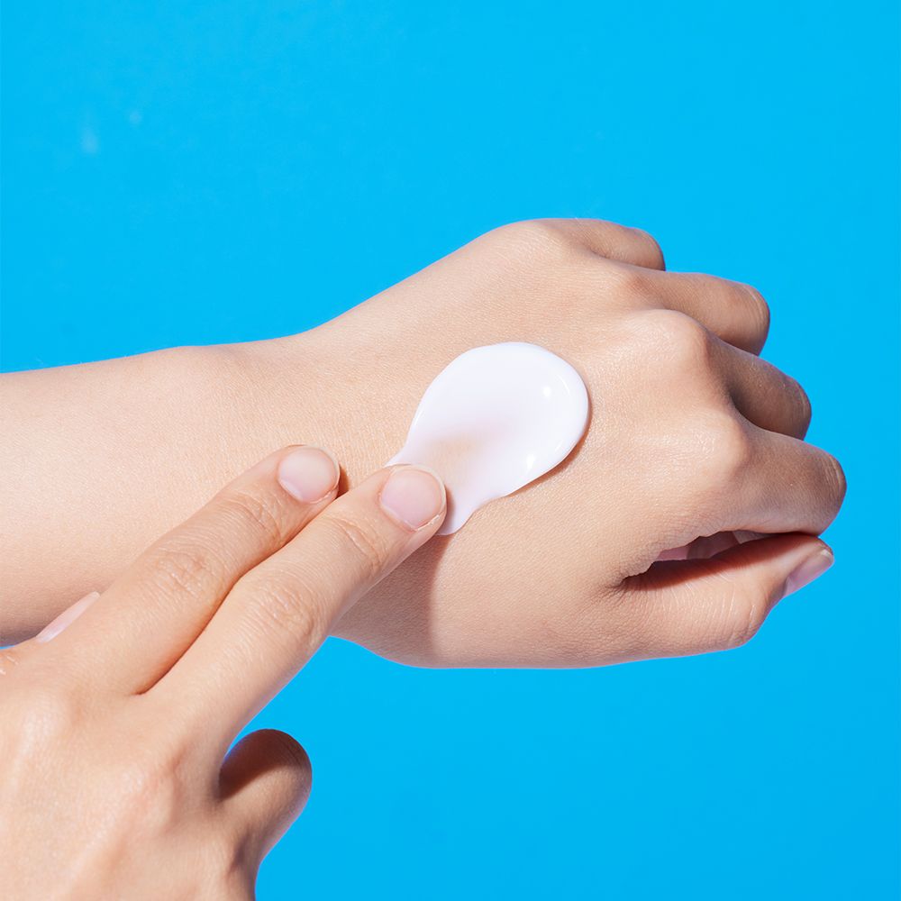 La crema viene applicata su una mano per mostrare l'idratazione della pelle.