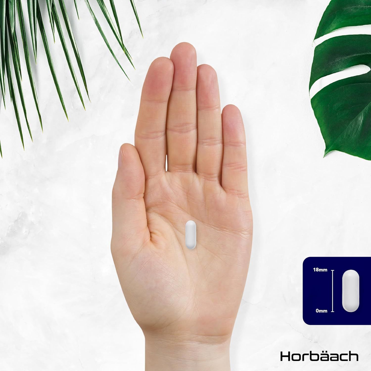 Mano che tiene una compressa ovale bianca. Dimensioni: 18mm x 6mm.