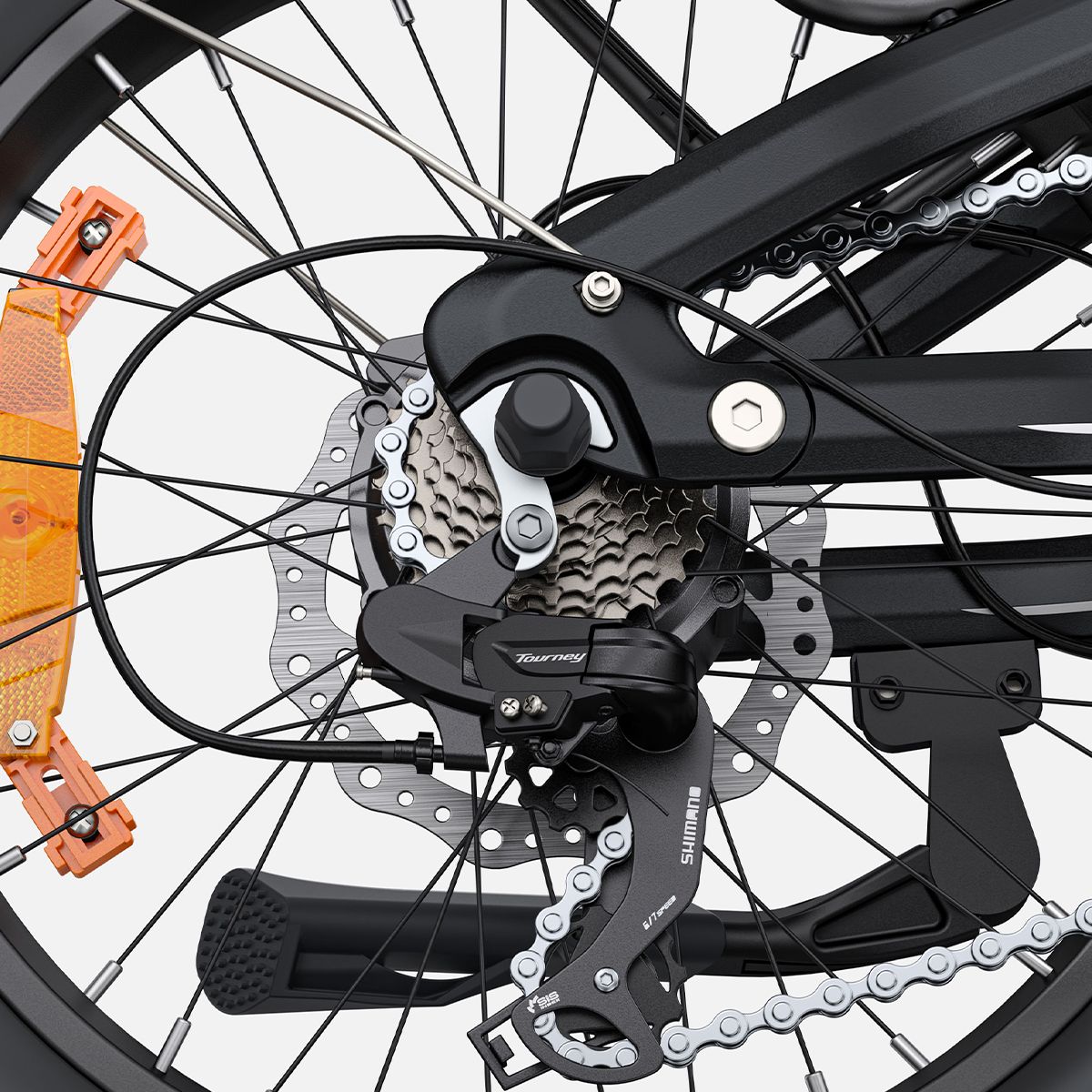 Primo piano della ruota posteriore di una bici elettrica. Componenti neri, catena e ingranaggi.