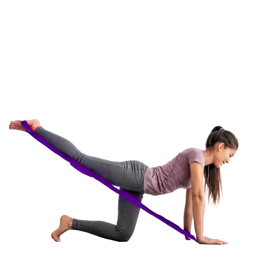 Una donna si allena con una fascia fitness viola. È in ginocchio e solleva una gamba, la fascia è intorno alla gamba e alla mano.