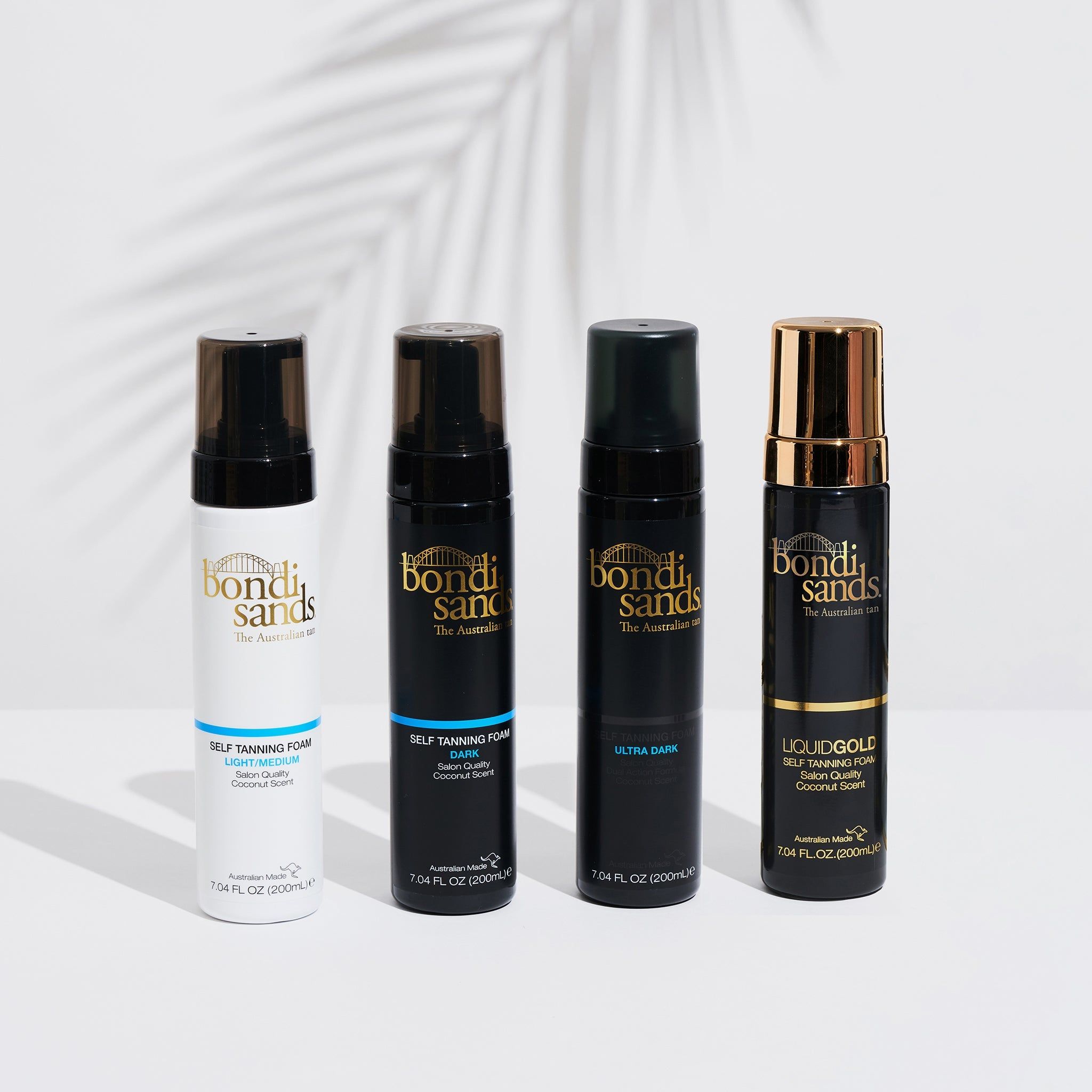 Quattro flaconi di schiuma autoabbronzante. Scritte: Bondi Sands, Light Medium, Dark, Ultra Dark, Liquid Gold. Flaconi neri e bianchi.