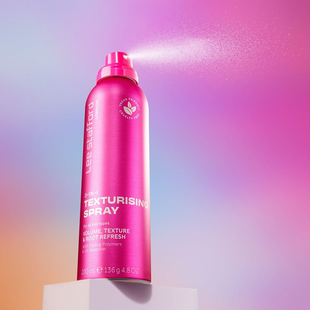 Lee Stafford 3-in-1 Texturising Spray, rosa, nebulizzazione, su un cubo bianco.