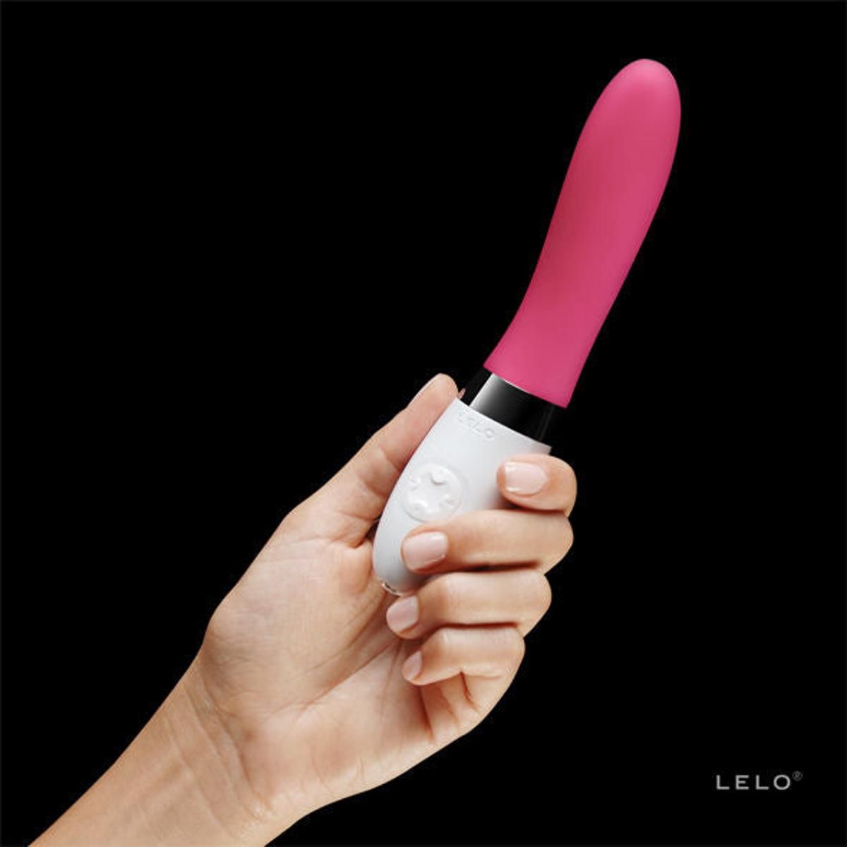 Vibratore rosa e bianco tenuto in mano. Il vibratore ha una forma arrotondata e il logo del marchio LELO.