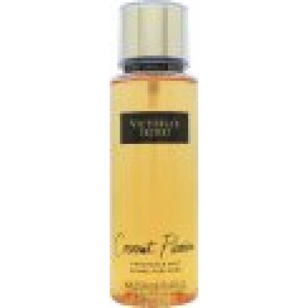 Flacone spray corpo con tappo dorato. Etichetta nera con nome prodotto e marchio. Liquido giallastro.