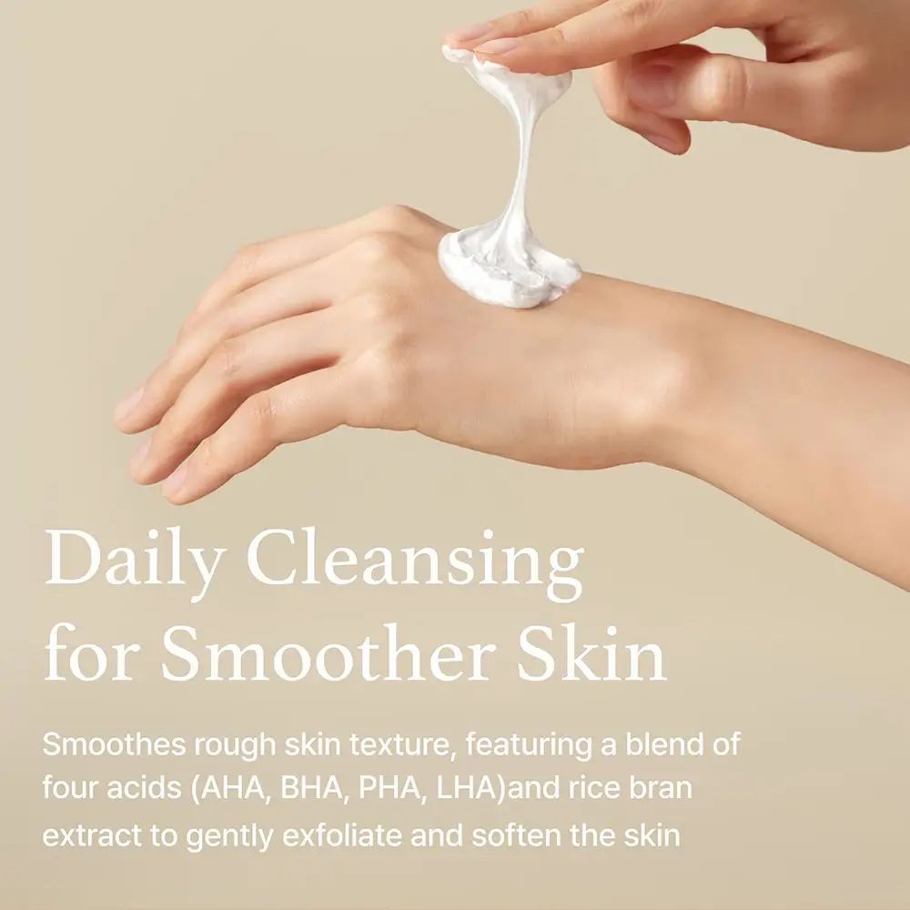 Mano con crema bianca. Testo: "Daily Cleansing for Smoother Skin". Descrizione degli ingredienti e dell'effetto sulla pelle.
