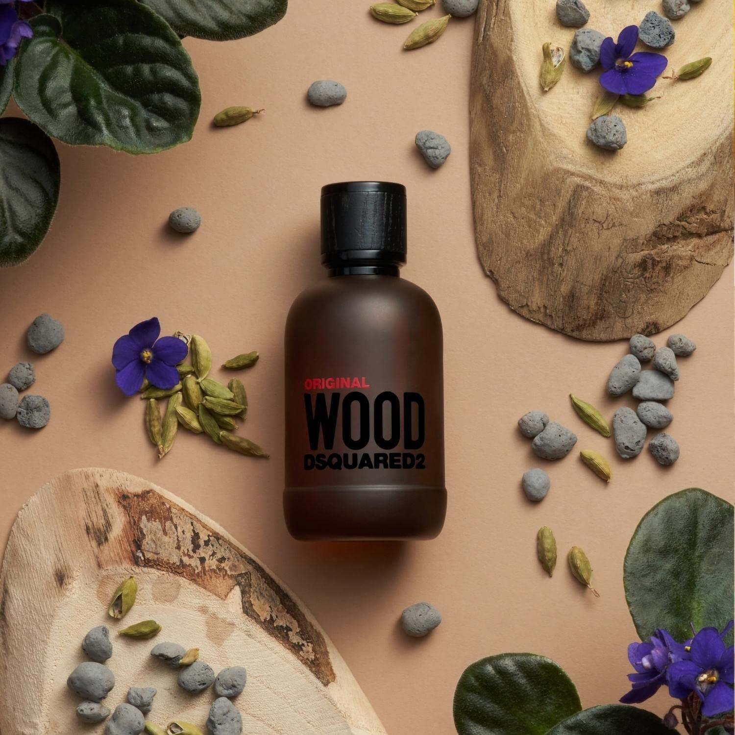 Flacone Dsquared2 Wood Original Eau de Parfum con tappo nero, circondato da materiali naturali.