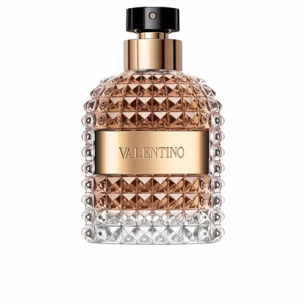 Flacone di profumo con elementi dorati e vetro goffrato. Scritta Valentino. Su sfondo bianco.