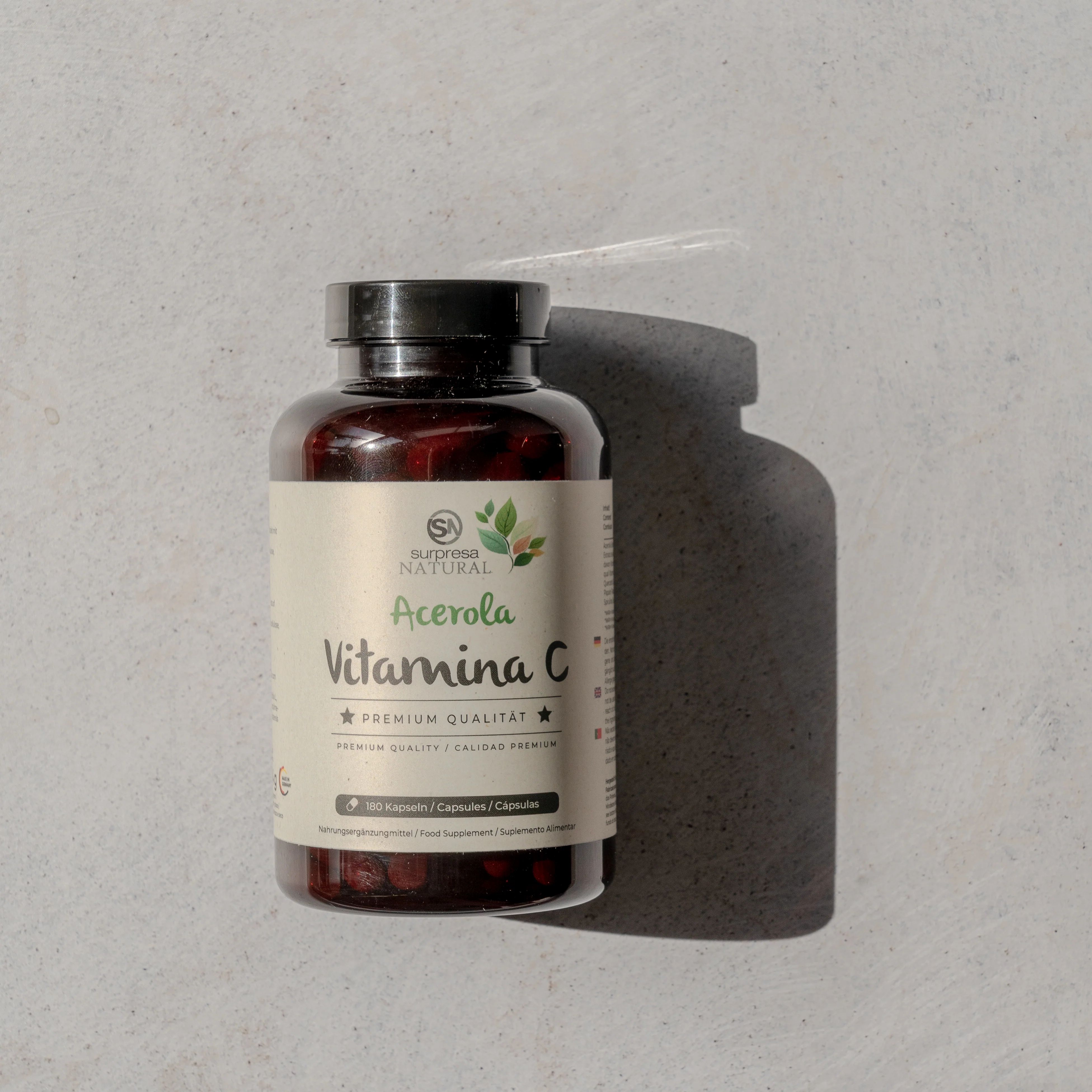 Flacone marrone con etichetta del prodotto. L'etichetta indica Acerola Vitamina C. Coperchio nero.