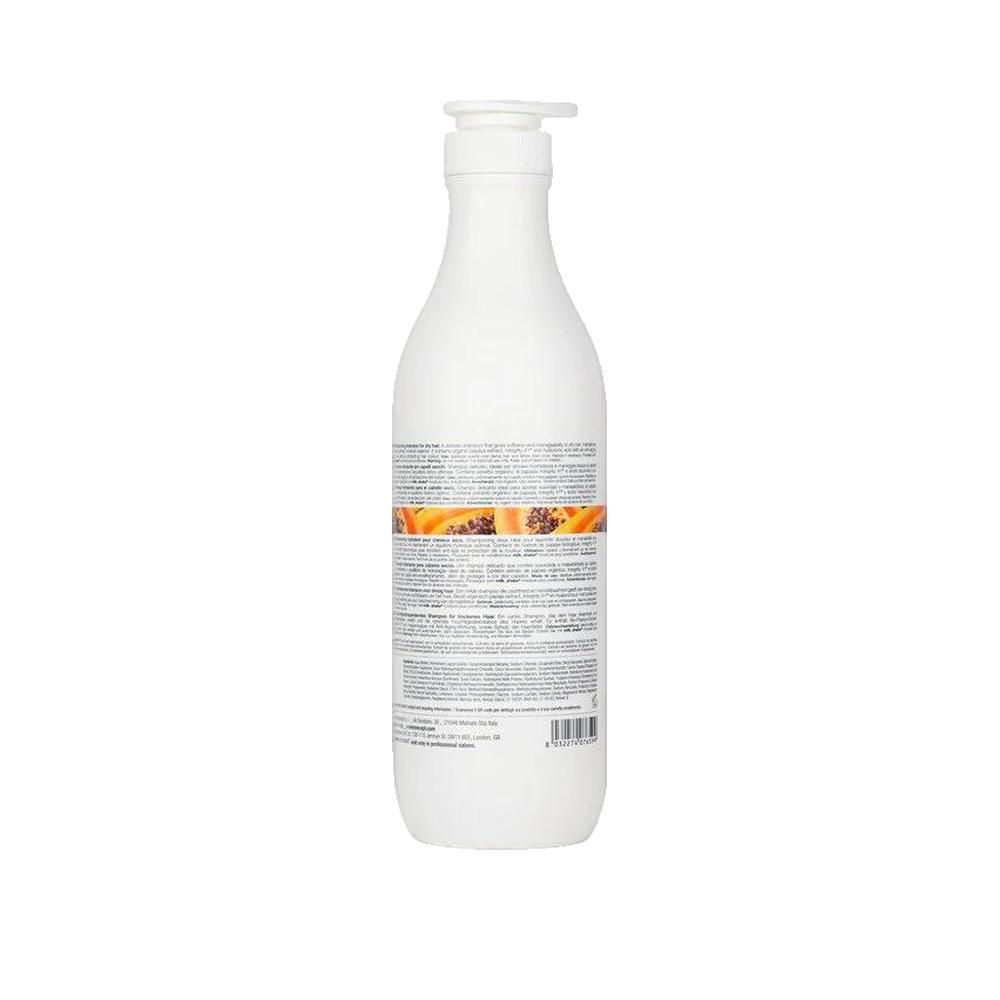 Retro di un flacone bianco con dosatore. Testo: milk_shake, moisture plus shampoo. Striscia arancione con immagine di papaya. Informazioni testuali.
