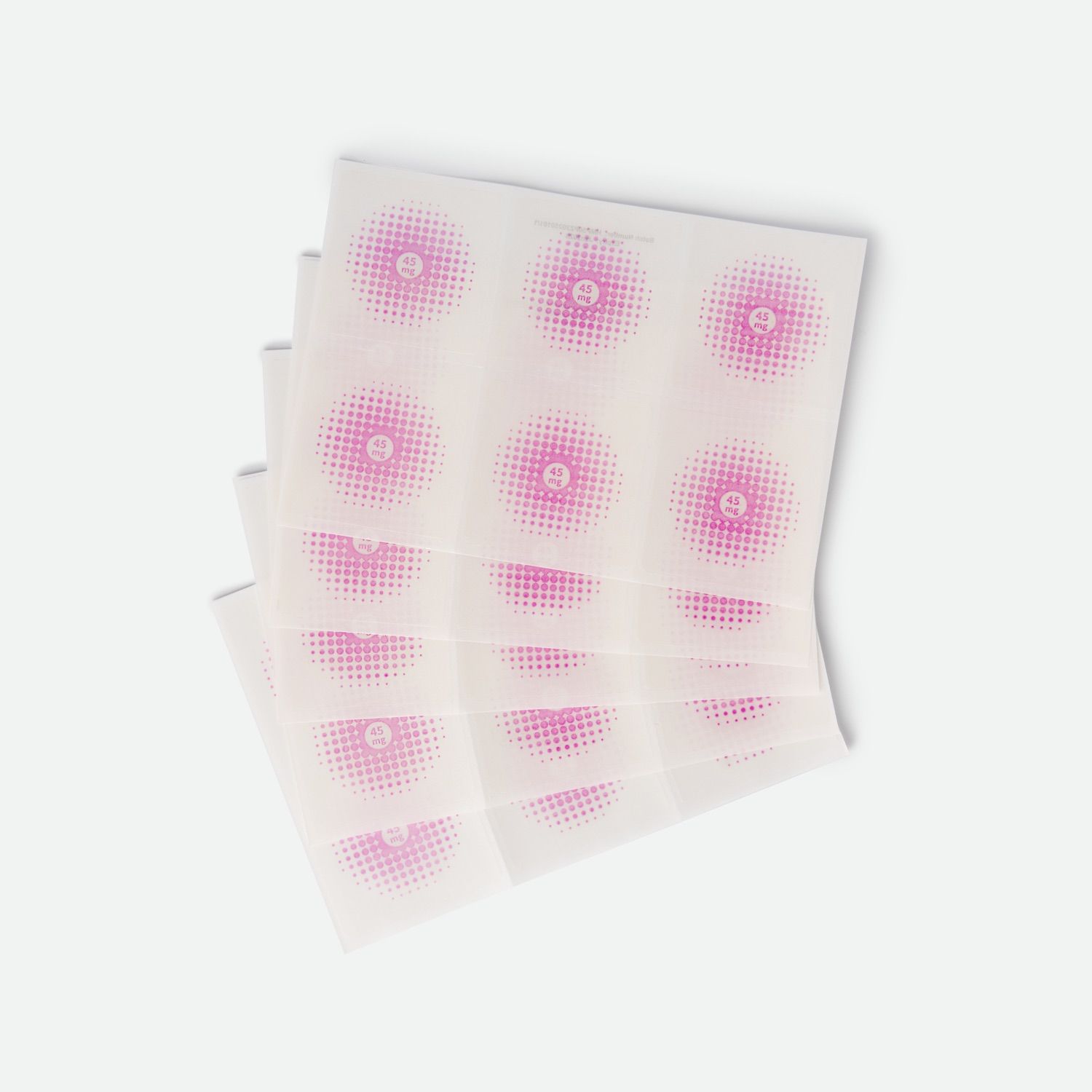 Più cerotti quadrati con motivo a punti rosa. Ogni cerotto ha un cerchio rosa al centro.