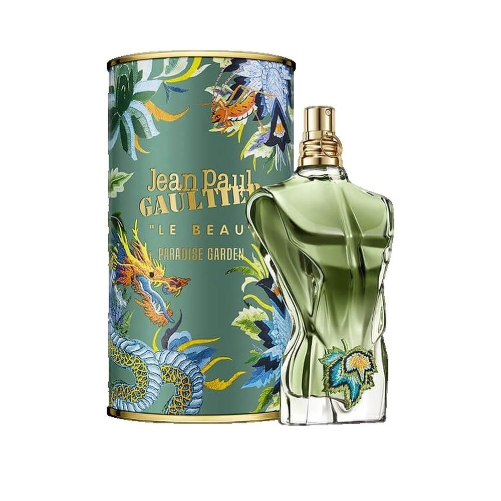 Flacone di profumo verde accanto a confezione cilindrica. Scritta "Jean Paul Gaultier" sulla confezione.