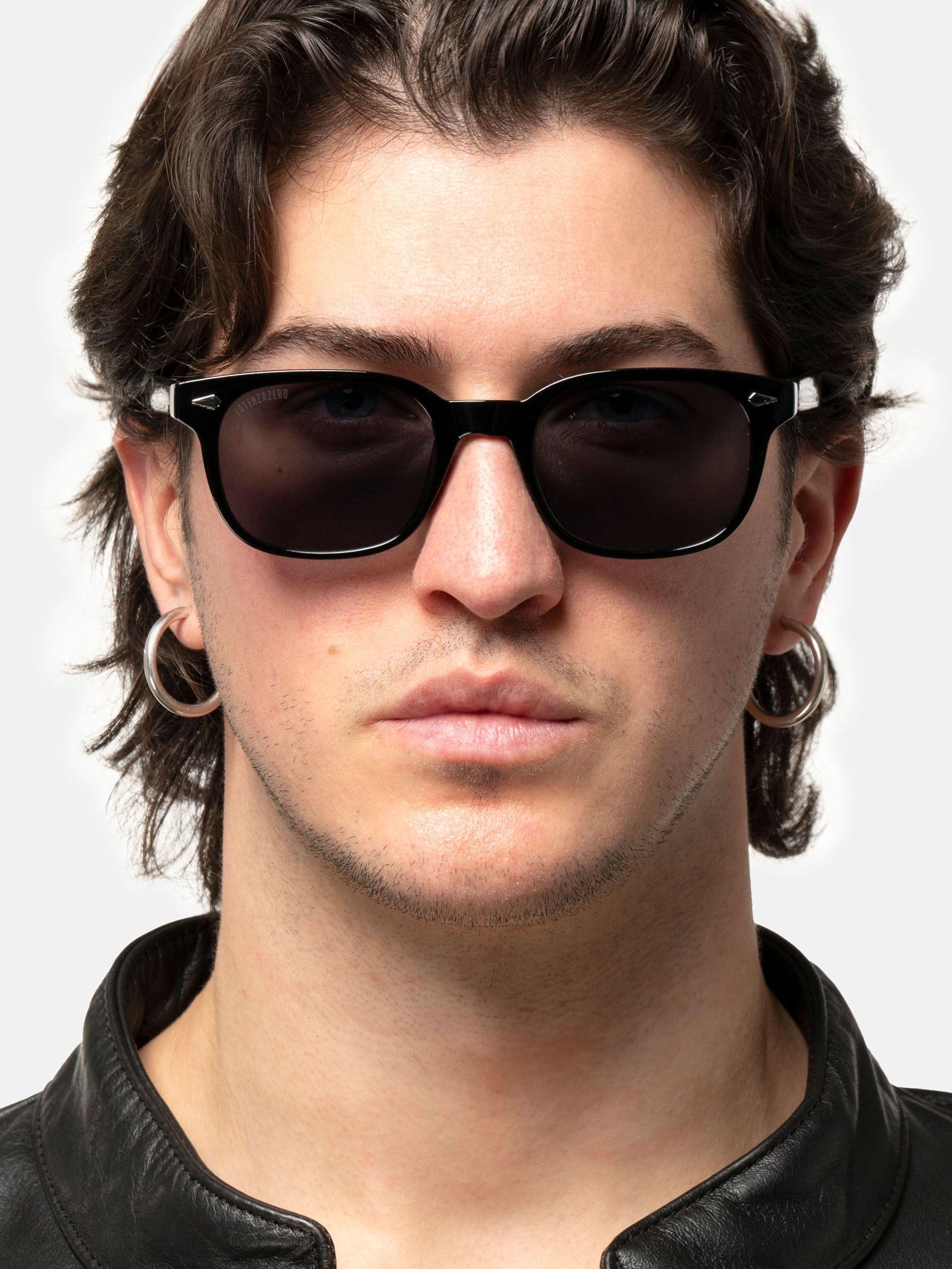 Uomo con occhiali da sole neri. Logo Latenzazero sull'asta.
